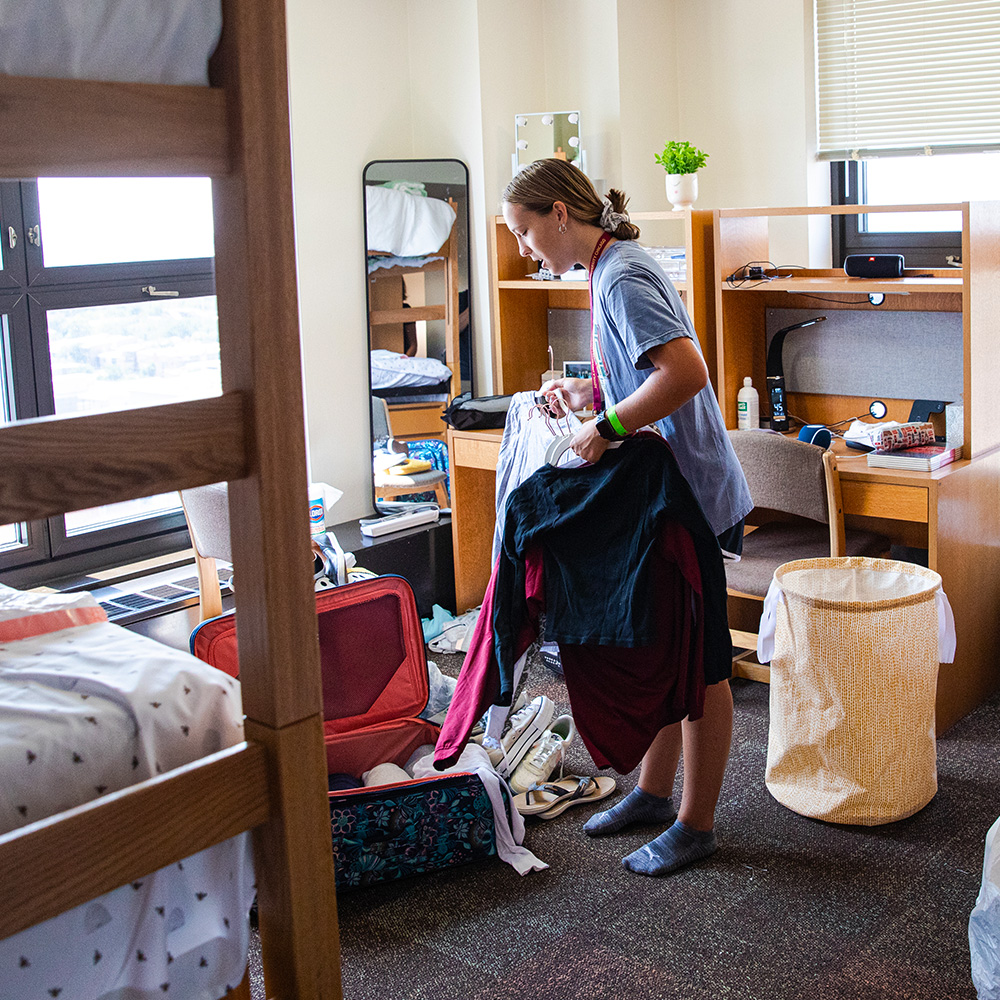 A Loyola student organizes their belongings as they settle into their new dorm room