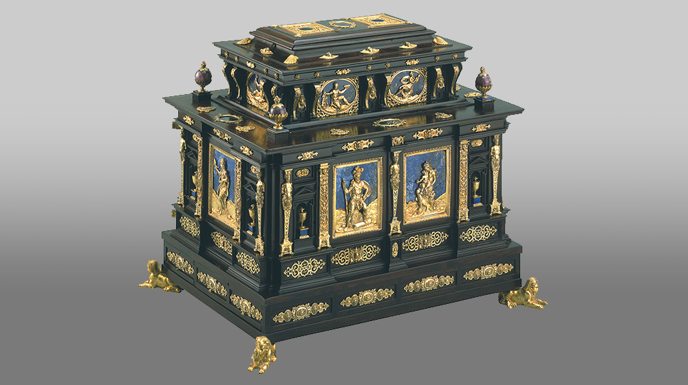 An ornate black and gold chest with navy blue accents and carved, gold feet. from the LUMA museum collection of art.